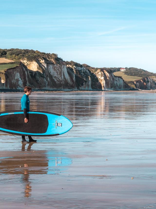 Jeune surfeur face aux falaises