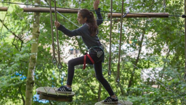 Jeune fille sur un parcours d'accrobranche