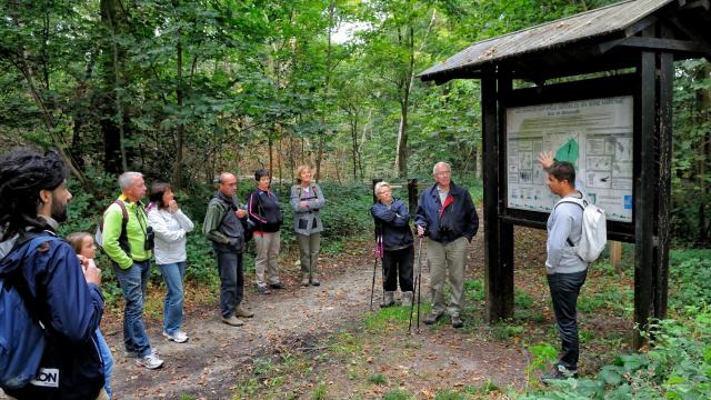 Groupe de personnes en visite dans un espace naturel sensible avec un guide