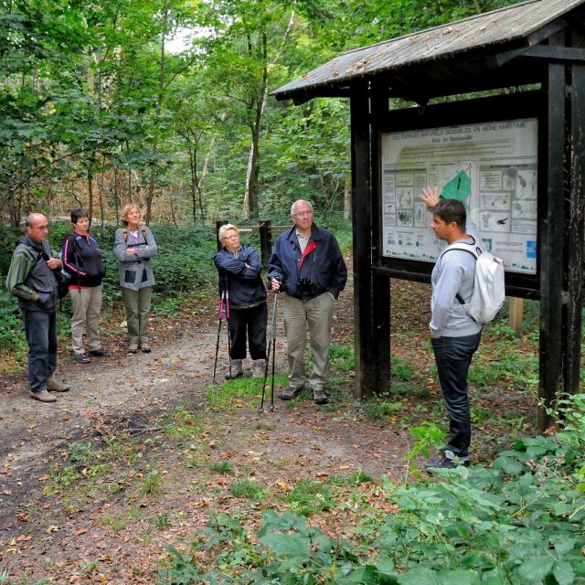 Groupe de personnes en visite dans un espace naturel sensible avec un guide