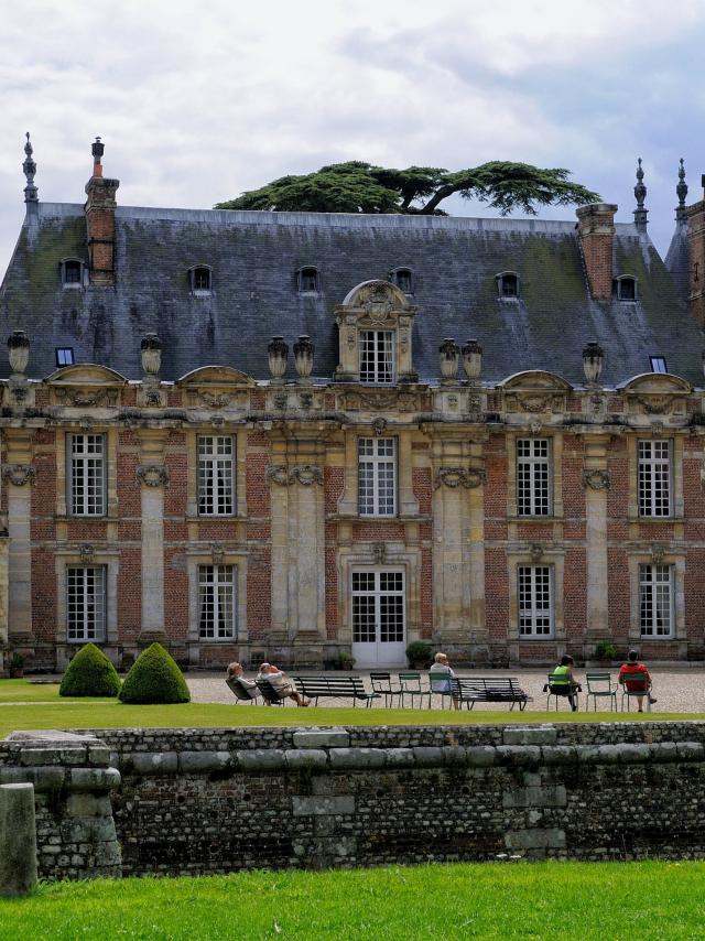 Façade nord style Louis XIII du Château de Miromesnil, personnes sur des transats installées dans la cour