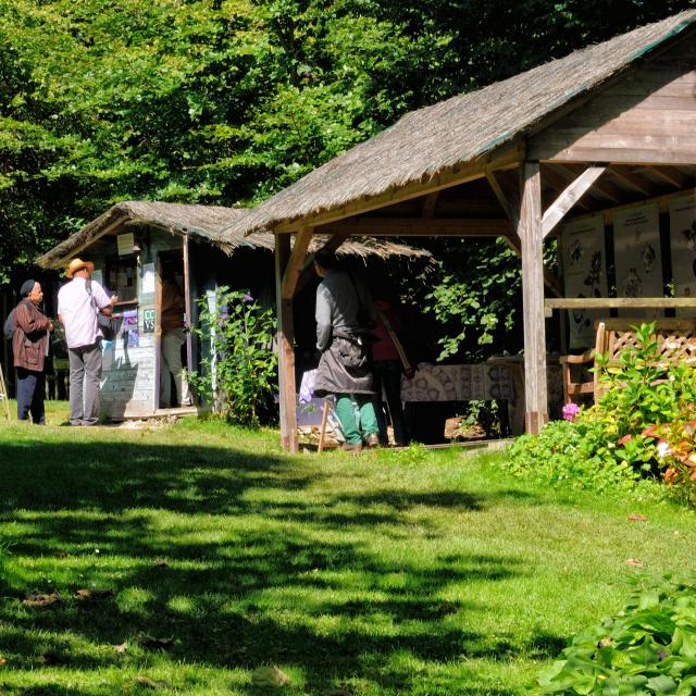 Cabane en bois de l'accueil du jardin. Préau en bois avec panneaux explicatifs