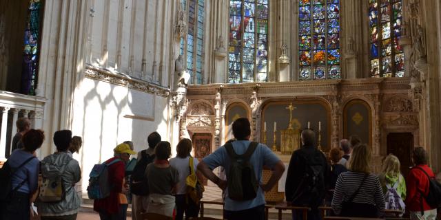 Des visiteurs regardent les vitraux à l'intérieur de l'église d'Arques-la-Bataille.