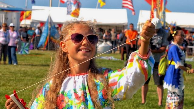 Petite fille souriante faisant voler un cerf-volant