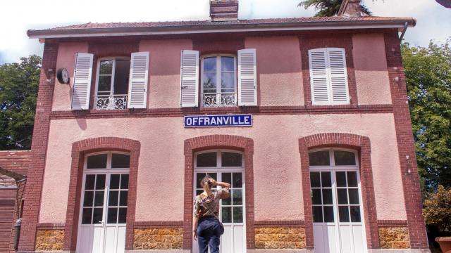 Jeune femme de dos devant l'ancienne gare d'Offranville