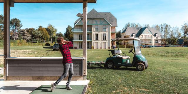 Golfette et jeune homme jouant au golf