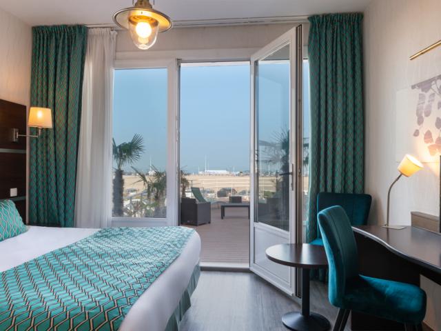 Chambre contemporaine aux tons turquoises avec une terrasse vue sur mer