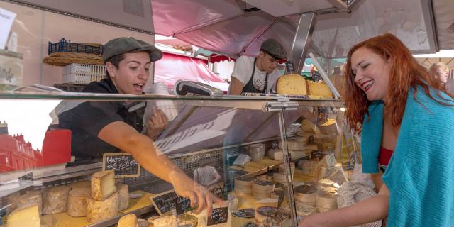 Les producteurs de fromage vendent leurs produits à une dame sur le marché de Dieppe