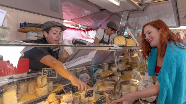 Les producteurs de fromage vendent leurs produits à une dame sur le marché de Dieppe