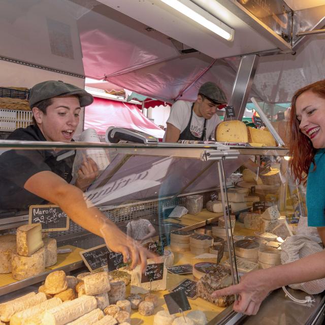 Les producteurs de fromage vendent leurs produits à une dame sur le marché de Dieppe