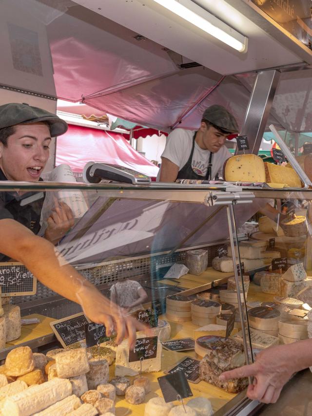 Les producteurs de fromage vendent leurs produits à une dame sur le marché de Dieppe