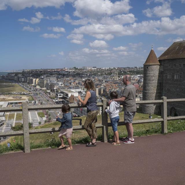 Un couple, un petit garçon et une petite fille de dos admirant le panorama sur la ville et la plage depuis l'esplanade du Château de Dieppe