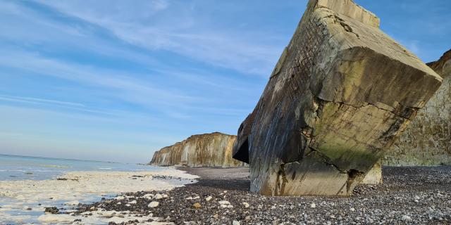 Bunker planté par angle dans la plage. Vue sur les falaises à l'arrière-plan