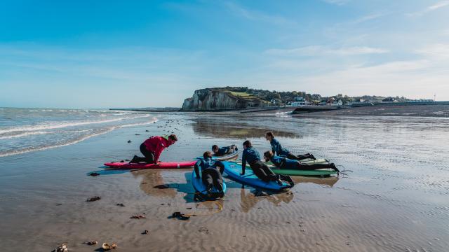 Moniteur donnant un cours de surf à cinq élèves