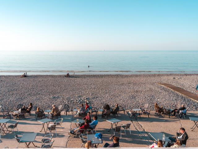 Personnes prenant un verre en terrasse sur la plage de Dieppe