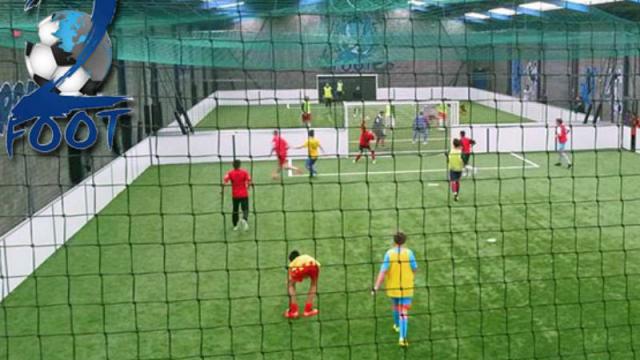 Match de football en intérieur vue à travers les filets du gardien