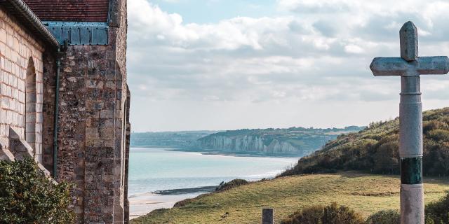 Jeune homme admirant le point de vue donnant sur la côte avec les falaises depuis le cimetière marin de l'église St Valery.