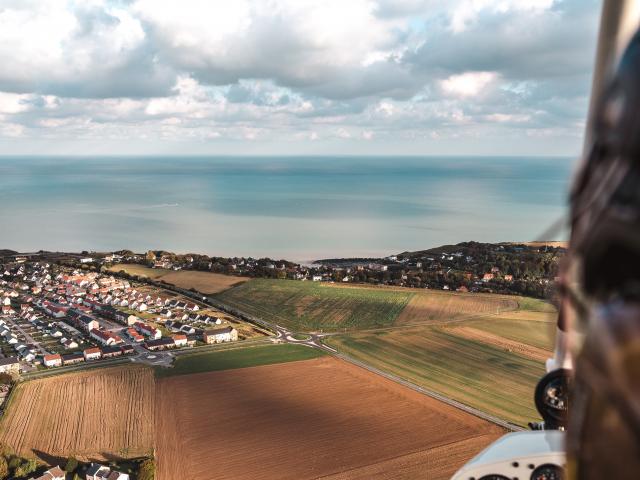 Vue du ciel sur la mer, sur la campagne et sur des habitations