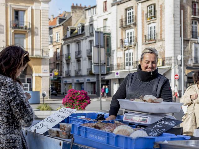 Une femme de pêcheurs vend des coquilles Saint-Jacques sur le marché aux poissons de Dieppe.