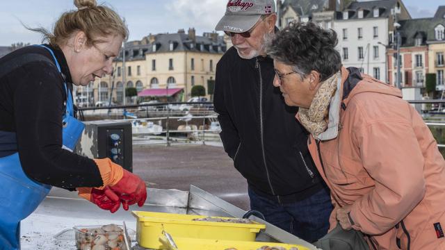 Une femme de pêcheur vend des coquilles Saint-Jacques sur le marché aux poissons de Dieppe.