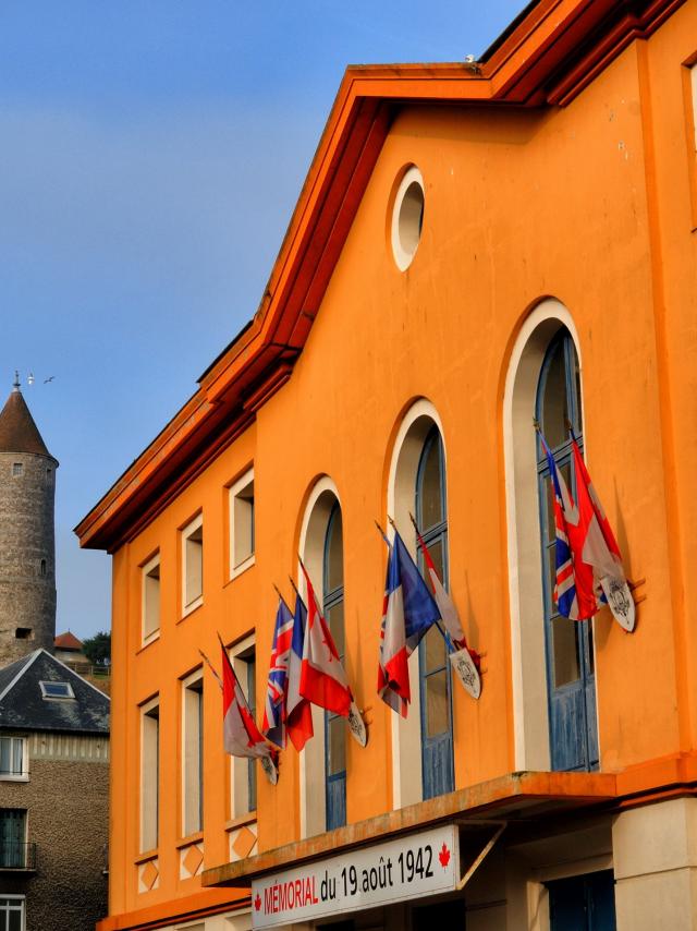 Façade jaune du Mémorial du 19 août 1942, situé dans l'ancien théâtre à l'italenne, château en arrière-plan