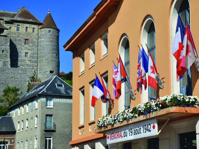 En contre-bas du Château, le petit théâtre et sa façade jaune-orangée agrémentée de drapeaux français, anglais et canadiens qui abrite le Mémorial retraçant l'histoire du raid du 19 août 1942