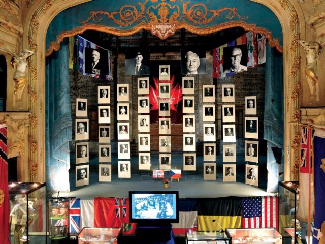 Portraits des vétérans installés en suspension sur la scène de l'ancien théâtre à l'italienne du Mémorial du 19 août 1942