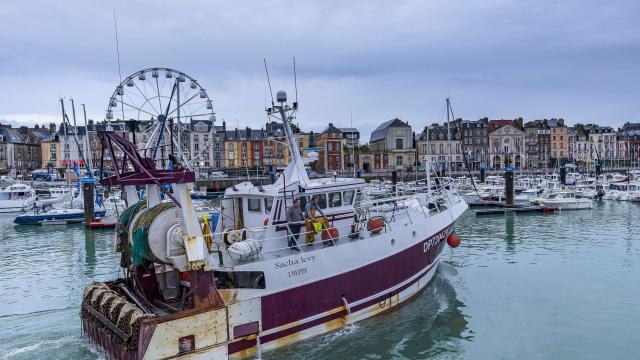 Bateau de pêche quittant le port, quai Henri IV et grande roue en arrière plan