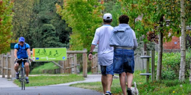 2 personnes à pied et un homme en vélo se baladent sur l'Avenue Verte