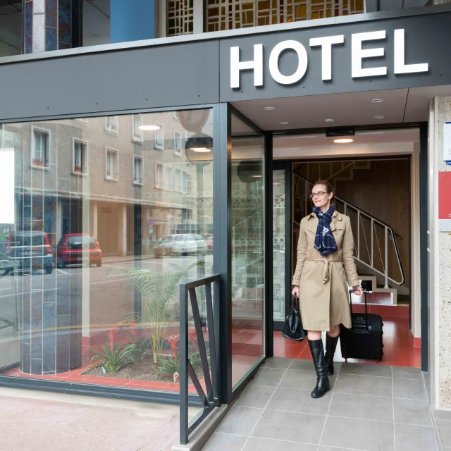 Femme avec une valise sortant de l'Hôtel de l'Europe de Dieppe