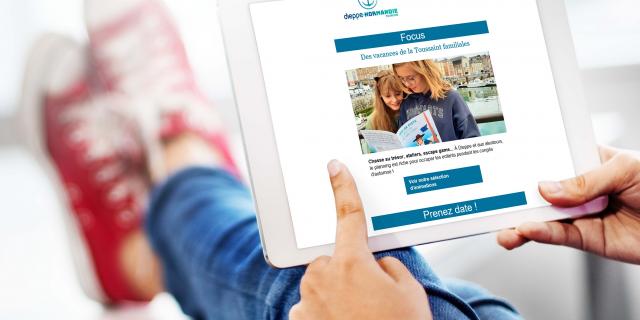 Personne lisant la newsletter de Dieppe-Normandie Tourisme sur une tablette