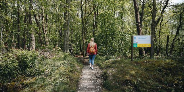 Jeune femme sur un chemin de randonnée à la végétation verdoyante