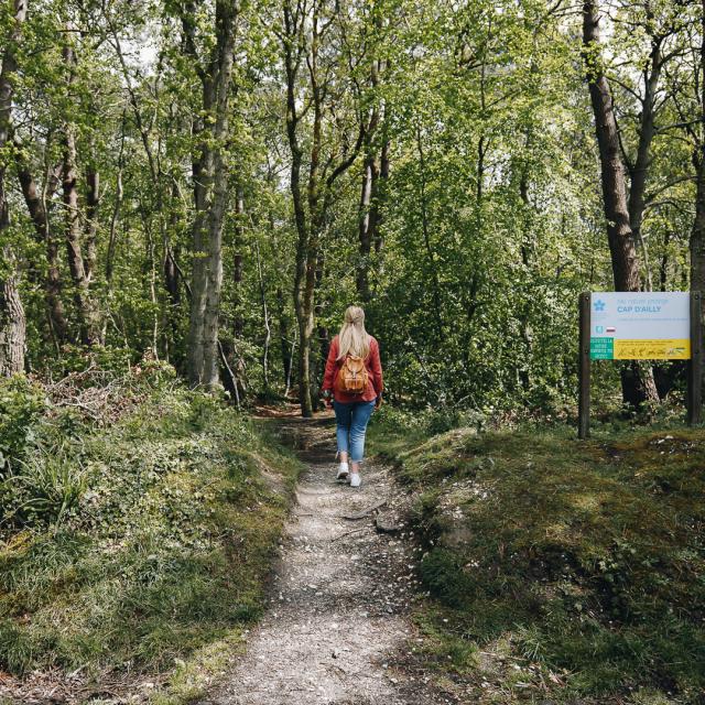 Jeune femme sur un chemin de randonnée à la végétation verdoyante