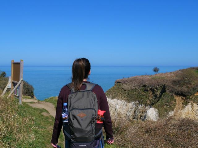 Jeune femme admirant la mer depuis le haut des falaises