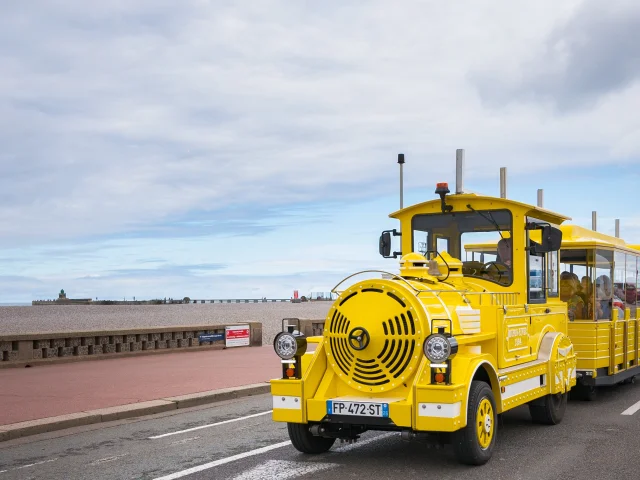 Le petit train touristique jaune rempli de visiteurs devant le front de mer de Dieppe