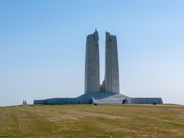 Un monument commémoratif de plusieurs mettre de haut composé de deux rectangles sculptés en pierre blanche au-dessus d'une pyramide de marches au milieu d'une grande étendue d'herbe.