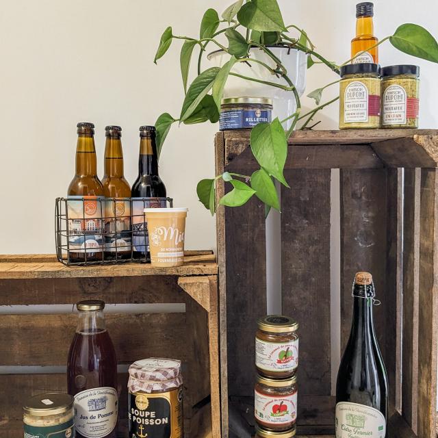 Des produits locaux de la région de Dieppe disposés sur des casiers en bois : rillettes de maquereaux, moutarde de la Maison Dupont, bières de la brasserie dieppoise, miel Fourneaux, risotto aux Saint-Jacques, soupe de poissons, cidre et jus de pommes de la Gentilhommière, caramels de pommes dieppois