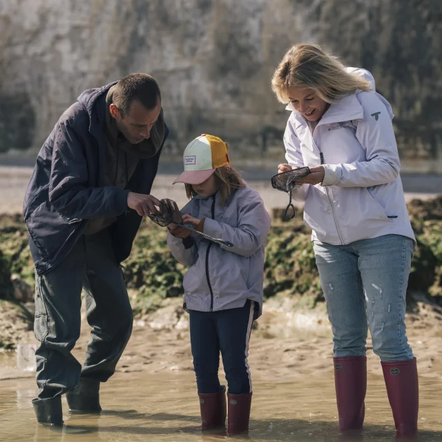 Une maman et sa famille, en compagnie d'un guide observent des animaux qu'ils viennent de pêcher