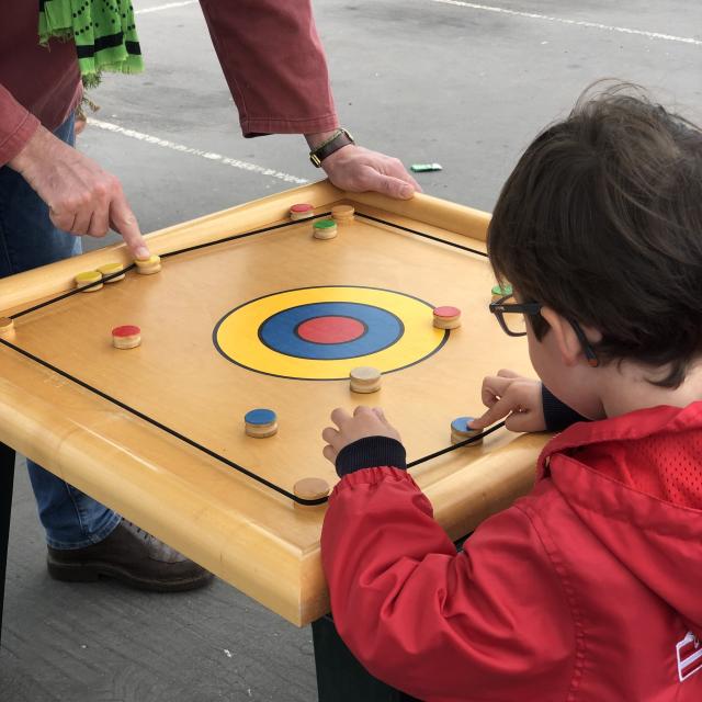 Un petit garçon joue sur un grand jeu en bois