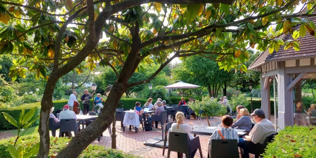 Groupes de personnes sur une terrasse écoutant un groupe de musique au parc du Colombier