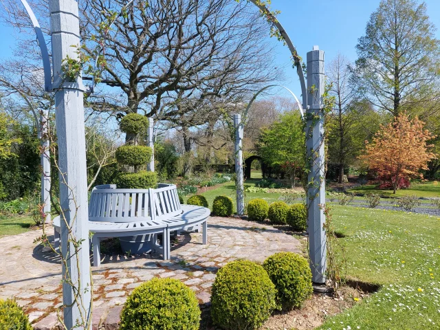 Place fleurie avec des bancs dans le Parc William Farcy sous un beau ciel bleu