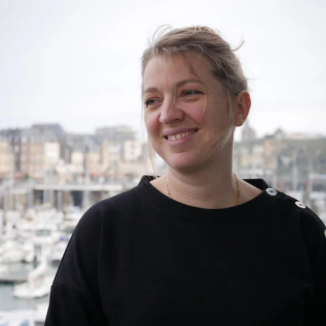 Photo de Sarah souriant avec le port de plaisance de Dieppe en fond