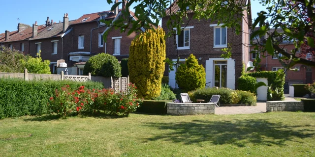 Maison en brique au coeur d'un jardin verdoyant