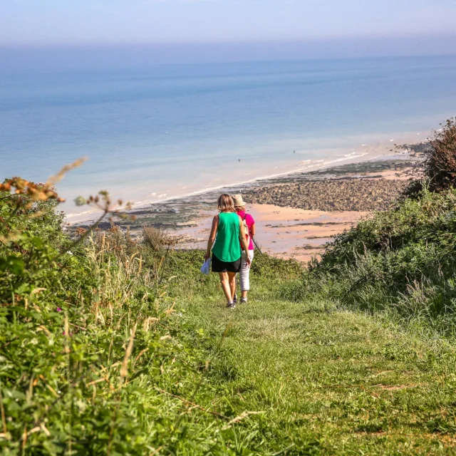 Deux femmes marchent vers la plage de Belleville, proche de la valleuse du Val au Prêtre à Petit-Caux