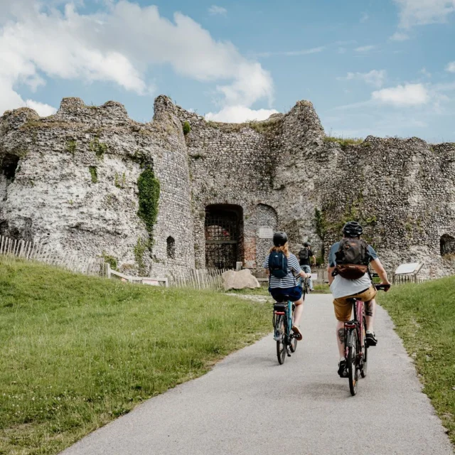 Cyclistes arrivant aux ruines du château d'Arques, vestiges d'un château médiéval en pierres